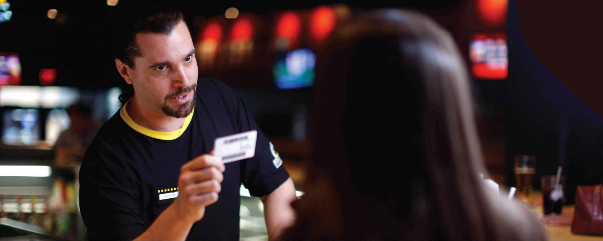 man at bar reviewing ID