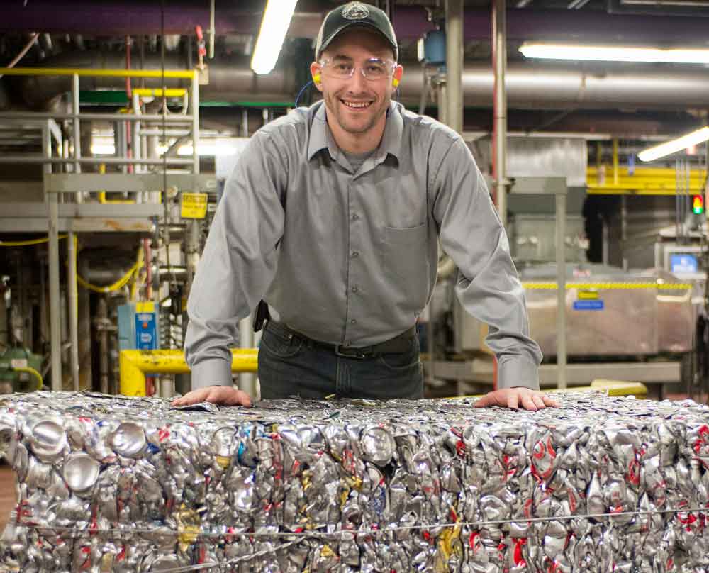 Man at factory with recycled beer cans