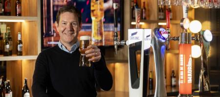 Simon Kerry stands behind a Carling pump